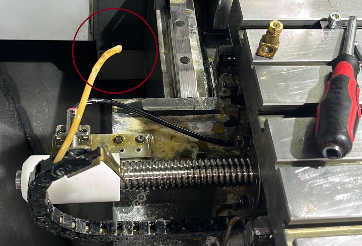 Defekte Schmierleitung an einer CNC-Maschine, markiert während der Wartung